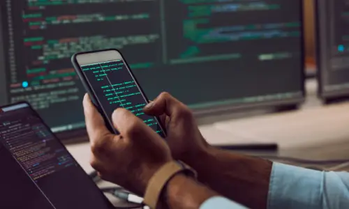 A person setting up applications on a phone and computer at the same time.