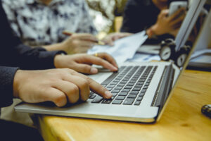 Person using a laptop to read articles about Microsoft Intune migration for small businesses.